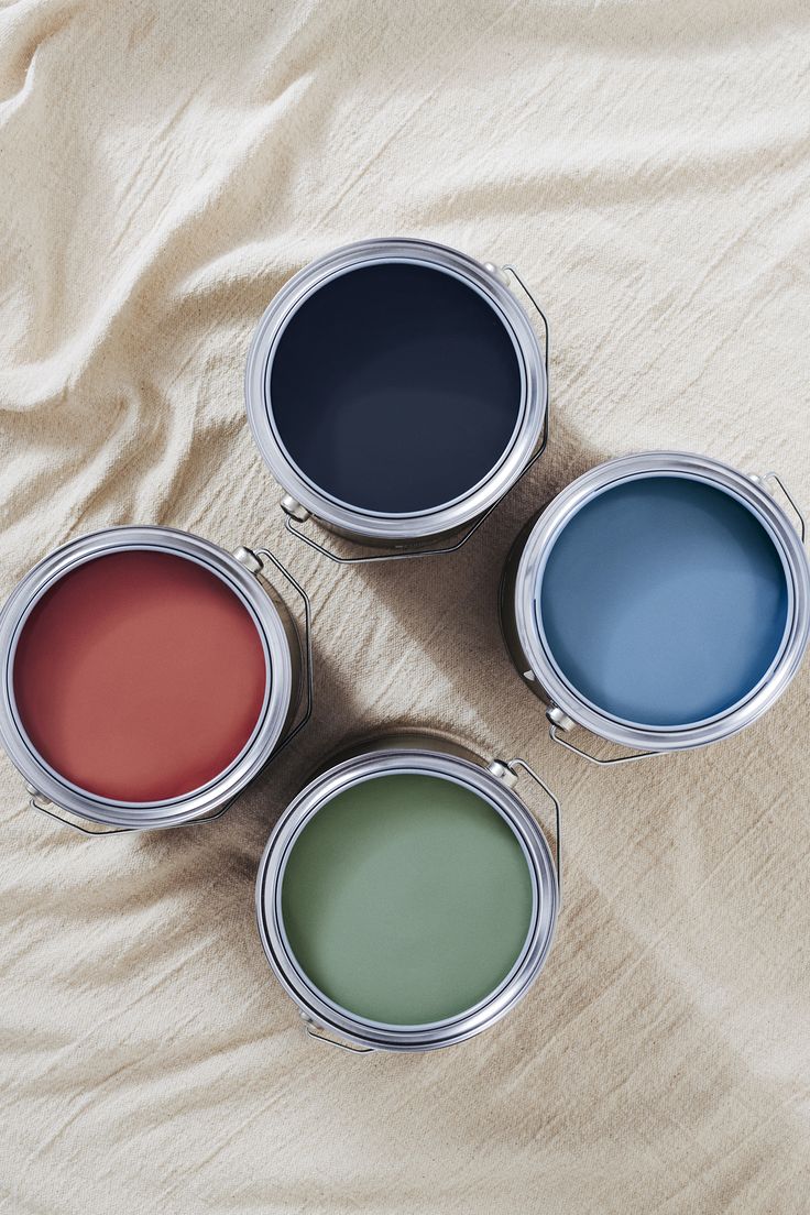 Open tins of terracotta, green, blue and charcoal Mix Lab paints